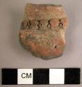 Red ware rim potsherd with filleted perforated band
