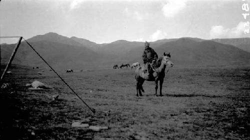 Man riding pony near mountains