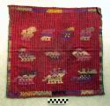 Tzute. red abd blue background with yellow purple, blue, etc. embroidery.