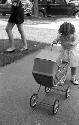 Small girl pushing baby buggy
