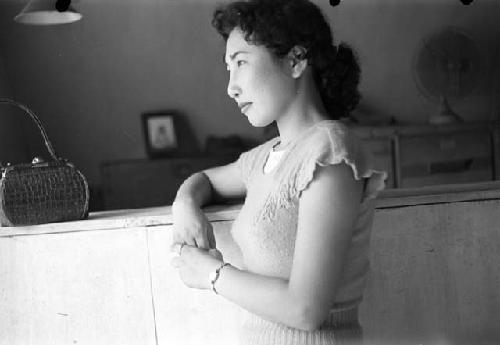 Woman standing in front of ledge with purse on it