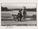 Three children in Hydaburg, Alaska with a bicycle and totem