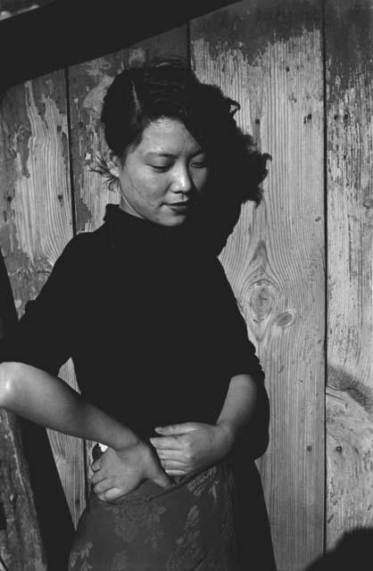 Young woman standing in front of wooden wall