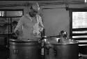 Man stirring one of our big metal pots.