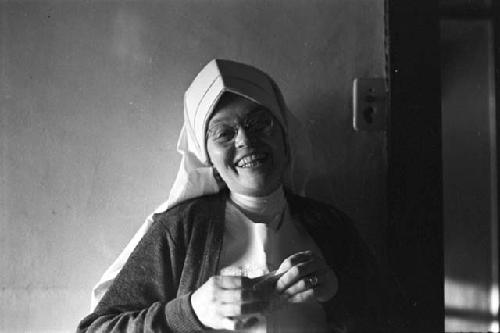 Smiling Nun holding a piece of paper.