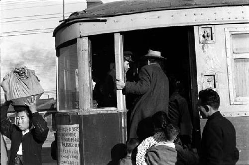 Man with children boarding trolley.