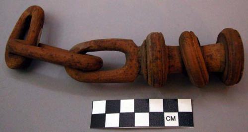 Ornament, carved wood, knobbed, looped spool attached to two chain links