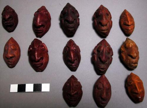 Nuts or pits, some whole, others halves, carved in sepik style, depicting human