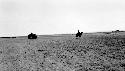 People riding camels through desert