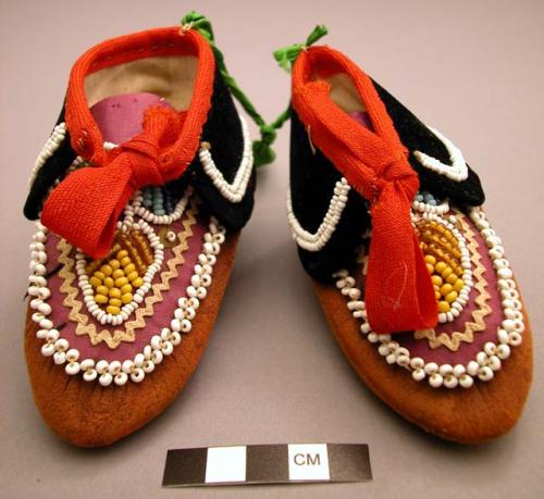 Child's moccasins. Red leather, black velvet and purple cotton, trimmed.