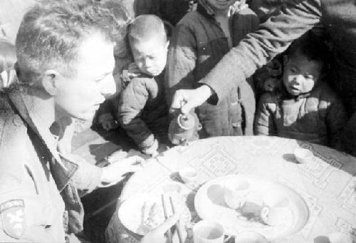 Soldier eating in front of children