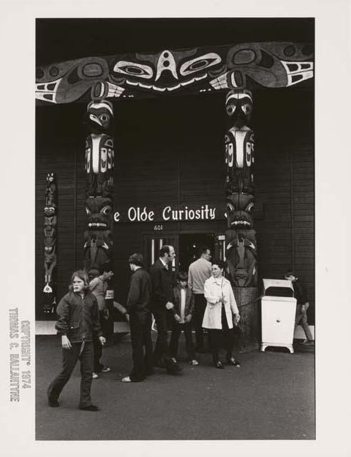 People outside gift shop in Seattle, Washington with totem poles