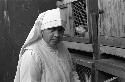 Nun in front of Guinea Pig cages.