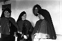 Four nuns standing in front of porthole on ship.