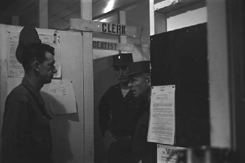 General William S. Whitcomb and two soldiers in base office.