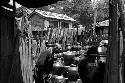 Man in junkyard with piles of pots.