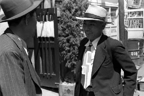 Two men in business suits talking to each other.