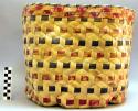 Rectangular carrying basket with hexagonal bottom. Decorated with red +