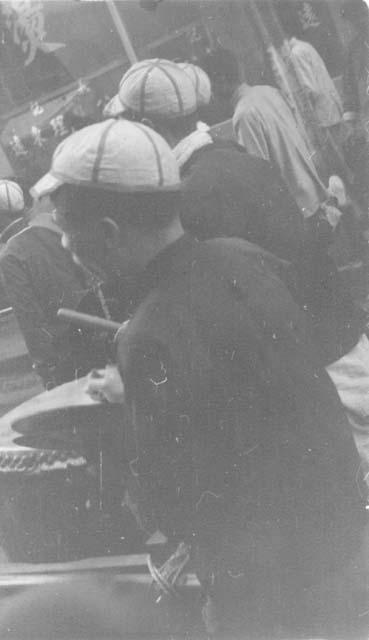 Men playing drums at parade; titled "Crash, Bang!"