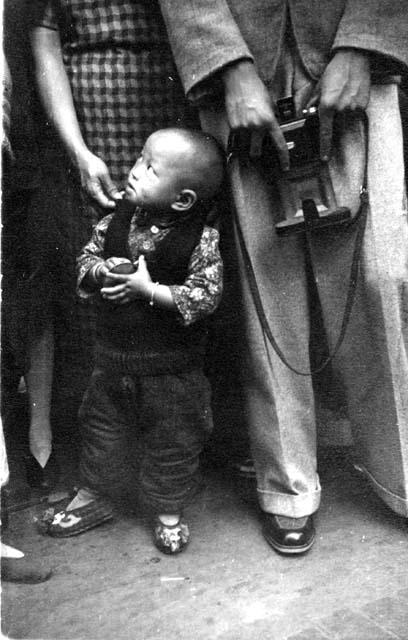 Young boy at parade; titled "Rich family son"