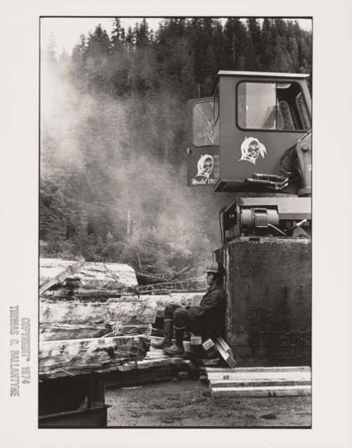 Logger sitting outside his vehicle among fallen trees