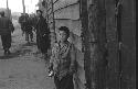 Young boy standing in unpaved street scene