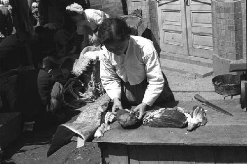 Woman preparing food on a counter outdoors.