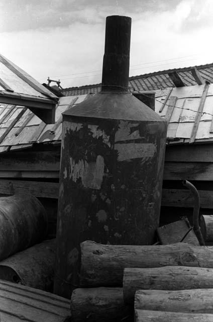 Metal container sitting on pile in junkyard.