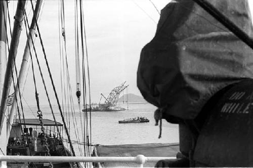 Ship with many riggins in foreground; sea and other boats behind ship.