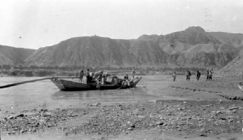 People in boat on river near mountains