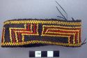 Arm band - basketry; dark brown with yellow and red design
