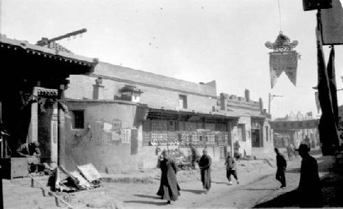 People walking down road in front of buildings