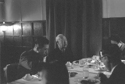Same man at table; military officer next to him.