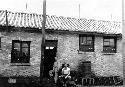 Men posing in front of house