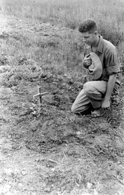 Soldier kneeling by grave