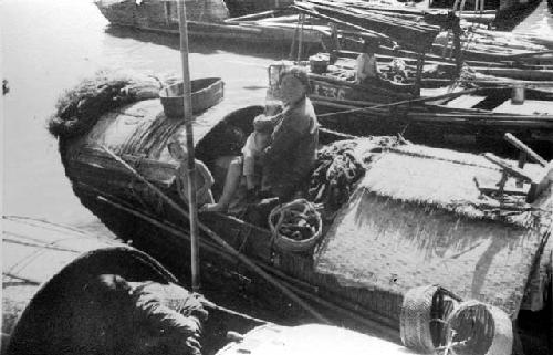 Sampan family on boat in harbor