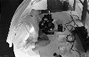 Nun writing notes on paper next to microscope.