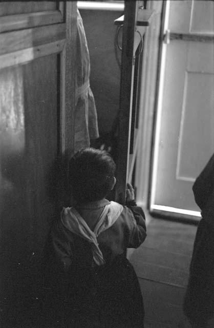 Small child walking towards open door.