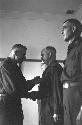 Two military men shaking hands at medal ceremony, while other two stand.