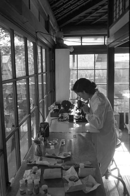 Woman looking into microscope.