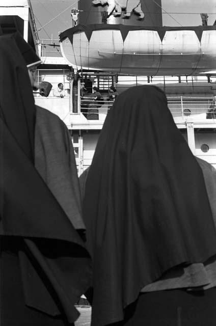 Two nuns looking at ship.