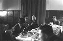 Men sitting at table in Dining Hall.