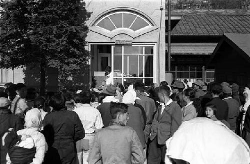 Crowd; Building with Fan Window