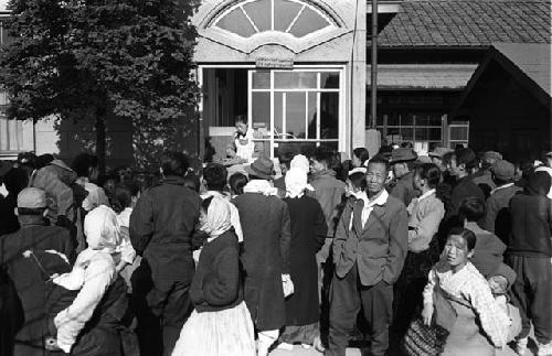 Crowd; Building with Fan Window