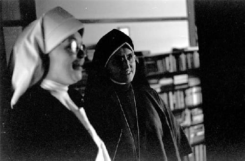 Two nuns; One with a white habit the other with black.