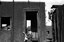 Boy in doorway of train; another boy climbing onto roof of train.