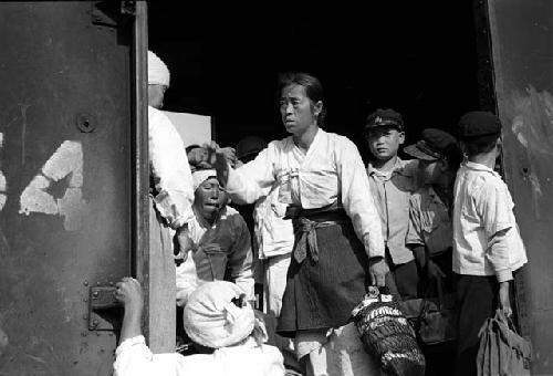 Women and children in doorway of train car.