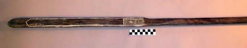 Palm wood club with engraved ornament inlaid with white