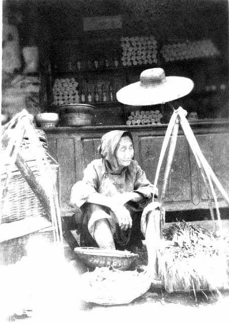 Woman selling vegetables; titled "Peasant selling goods."