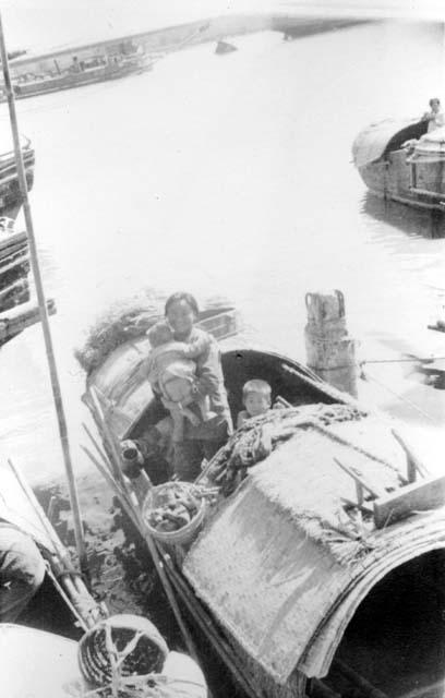 Sampan family on boat in harbor